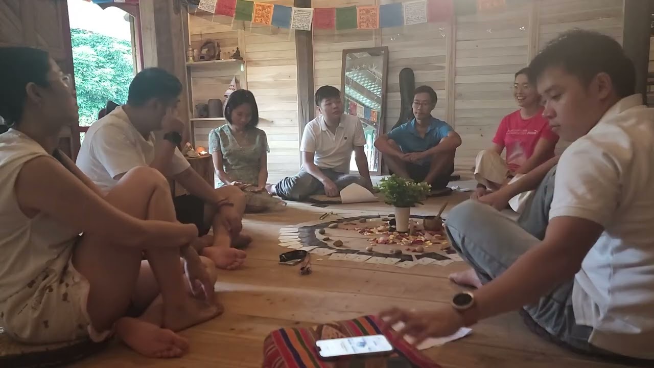Mọi người ngồi vòng tròn trong nhà sàn gỗ quanh mandala, cuối ngày